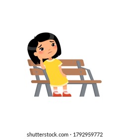 Lonely Kid Girl Is Bored In The Playground. Sad Little Asian Girl. Unhappy Child Sitting On Bench. Sick, Toothache Cartoon Character