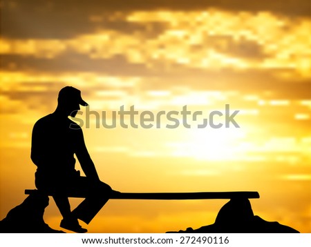 The lonely man sits on a bench against a decline