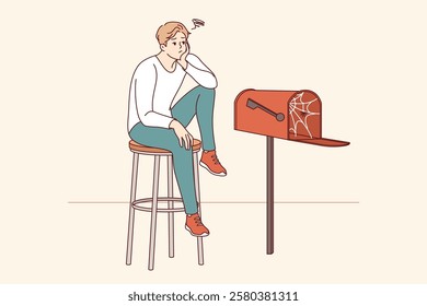 Lonely man waiting for letter, sitting by empty mailbox covered with cobwebs, wanting to receive messages from girlfriend. Lonely guy needs communication and suffers due to lack of friends