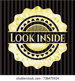 Look inside gold emblem or badge