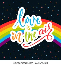 Love is in the air. Words on rainbow parade flag at dark sky with stars. Gay pride saying for stickers, t-shirts and posters