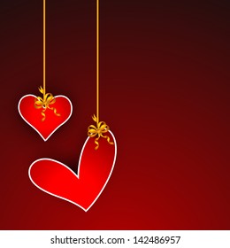 Love concept with hanging hearts on red background.