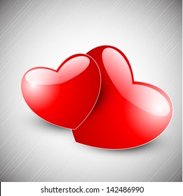 Love concept with red glossy hearts on grey background.