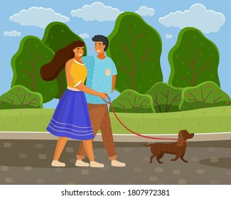 In love couple of young girl and guy wallking with dog at leash in summer park along road, happy people spend time together outdoors at nature, leisure activity, green trees and bushes at background