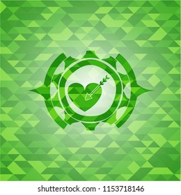 love icon inside green emblem with triangle mosaic background
