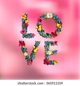 Love lettering with flowers on blurred background