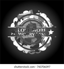 Love More Worry Less written on a grey camouflage texture