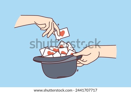 Love notes or wishes inside hat and hands of people playing romantic game for spouses or bride and groom. Man randomly chooses card with romantic wishes to have good time with other half
