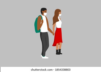 Love in times of coronavirus. Cute interracial young teenage couple holding hands and wearing masks. Beautiful girl with long brown hair, red dress and boots and african boy with green backpack