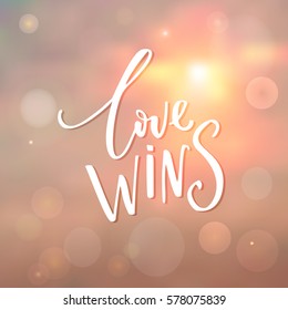 Love wins - inspirational quote at sunrise background with bokeh.