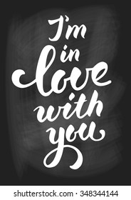 I am in love with you. Romantic card. Handwritten modern calligraphy poster with lettering by brush on chalkboard. Vector illustration.