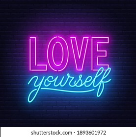 Love yourself neon inspirational quote on a brick wall.