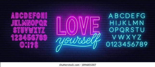 Love yourself neon inspirational quote on a brick wall.