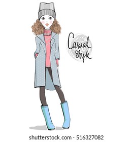 Lovely girl in autumn-winter clothes. Hand drawn cute teen with casual apparel. Hipster illustration. Personage in sketch style. Casual look. Vector girl in raincoat, hat, boots, sweater, pants.