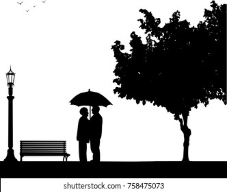 Lovely retired elderly couple stands under the umbrella in park in autumn or fall, one in the series of similar images silhouette