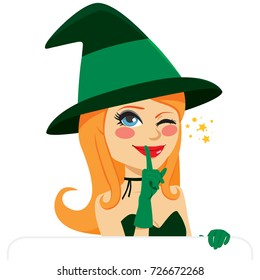 Lovely witch with white banner winking and making silence or secret hand gesture with finger on lips