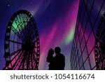 Lovers in amusement park at night. Vector illustration with silhouette of loving couple and Ferris wheel. Northern lights in starry sky