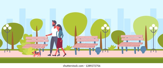 lovers couple walking with cute dog man woman spending time in city urban park cityscape background family pet animal best friend concept flat horizontal