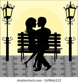 Lovers on the bench in the park under the lights