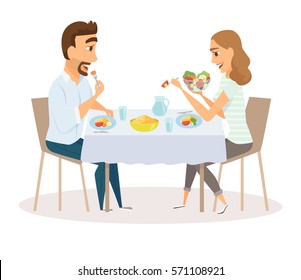 Loving couple eating meal in the kitchen table. Happy man and women sitting eating healthy lunch in home or restaurant. Diner family smile and laughing together.