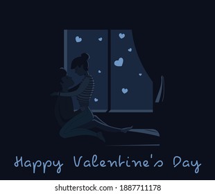 A loving couple, a guy and a girl hug each other in the room at night against the background of the window.