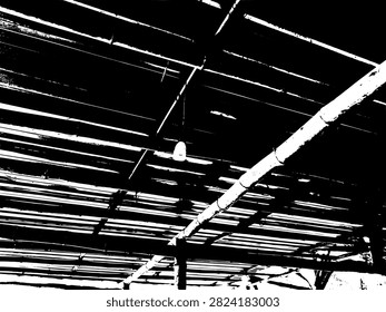 Low angle view of a light bulb hanging from bamboo rafters under a corrugated zinc roof in a rustic building.