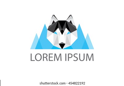 low poly logo - geometric polygonal husky dog head and blue mountains in the background - great logo element for winter outdoor business 