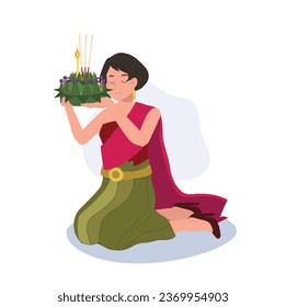 Loy Krathong Traditional Festival. woman in Thai traditional dress is sitting and hold krathong up to make a wish before float in river.