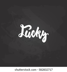 Lucky - hand drawn lettering phrase for Irish holiday Saint Patrick's day isolated on the black chalkboard background. Fun brush ink inscription for photo overlays, greeting card, poster design