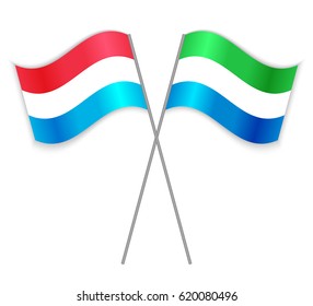 Luxembourgish and Sierra Leonean crossed flags. Luxembourg combined with Sierra Leone isolated on white. Language learning, international business or travel concept.