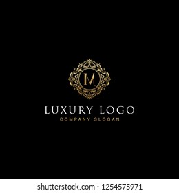 Luxurious elegant victorian floral filigree frame badge pattern with Initial letters M inside  circle badge emblem logo design vector in gold colors