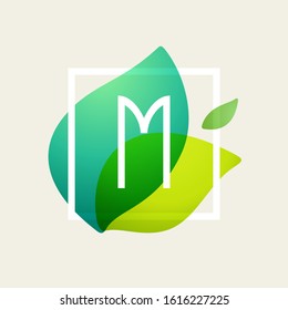 M letter logo in square frame at green leaves watercolor background. Vector ecology typeface for botanical labels, floral headlines, recycle posters, organic cards etc.