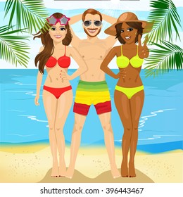 macho man standing with two attractive women on tropical beach