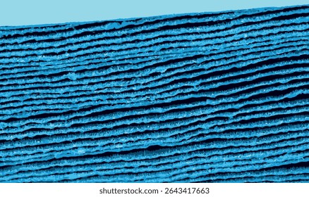Captura de macro de folhas de papelão onduladas azuis empilhadas vistas da borda, revelando textura em camadas e padrões lineares intrincados. Ideal para design, artesanato ou imagens de embalagem.