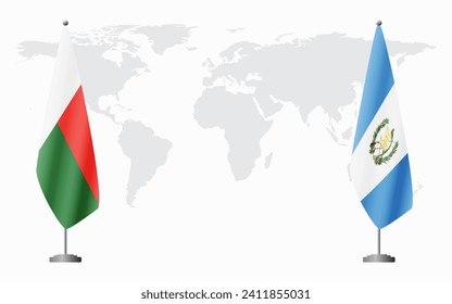 Madagascar and Guatemala flags for official meeting against background of world map.