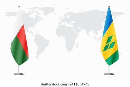 Madagascar and Saint Vincent and the Grenadines flags for official meeting against background of world map.