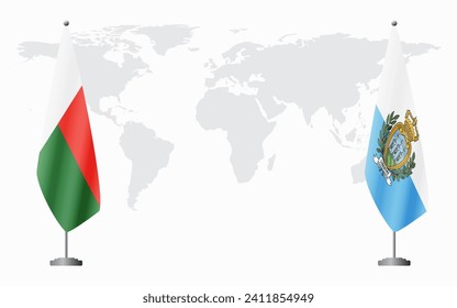 Madagascar and San Marino flags for official meeting against background of world map.