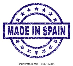 MADE IN SPAIN stamp seal watermark with grunge texture. Designed with rectangle, circles and stars. Blue vector rubber print of MADE IN SPAIN tag with grunge texture.