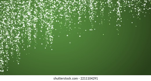 El fondo de navidad de la nieve cae mágicamente. Sutiles copos de nieve volando y estrellas sobre fondo verde navideño. Escenario de vacaciones de nieve en caída mágica.   Ilustración vectorial amplia.