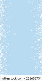 Magic falling snow christmas background. Subtle flying snow flakes and stars on light blue winter backdrop. Magic falling snow holiday scenery.   Vertical vector illustration.
