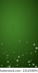 Magic falling snow christmas background. Subtle flying snow flakes and stars on christmas green background. Magic falling snow holiday scenery.   Vertical vector illustration.