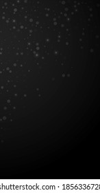 Magic stars random Christmas background. Subtle flying snow flakes and stars on black background. Alluring winter silver snowflake overlay template. Stylish vertical illustration.