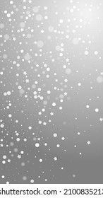 Magic stars random Christmas background. Subtle flying snow flakes and stars on grey background. Amusing winter silver snowflake overlay template. Lively vertical illustration.