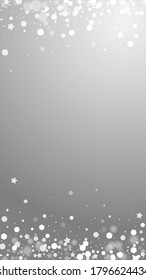 Las estrellas mágicas brillan por su ausencia. Sutiles copos de nieve volando y estrellas de fondo gris. Admirable plantilla de superposición de copos de nieve de plata de invierno. Impresionante ilustración vertical.