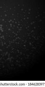 Magic stars sparse Christmas background. Subtle flying snow flakes and stars on black background. Appealing winter silver snowflake overlay template. Curious vertical illustration.
