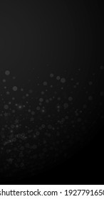 Magic stars sparse Christmas background. Subtle flying snow flakes and stars on black background. Amusing winter silver snowflake overlay template. Cool vertical illustration.