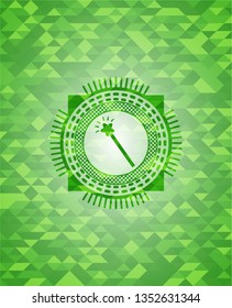 magic stick icon inside green mosaic emblem
