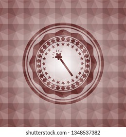 magic stick icon inside red seamless emblem with geometric pattern.