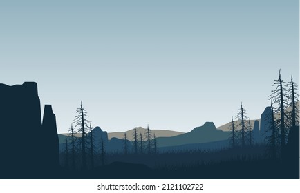 Magnificent mountain view from the edge of the cliff at dusk with the silhouettes of dry trees all around