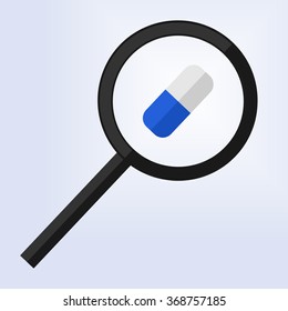 magnifying glass examining a blue and white pill